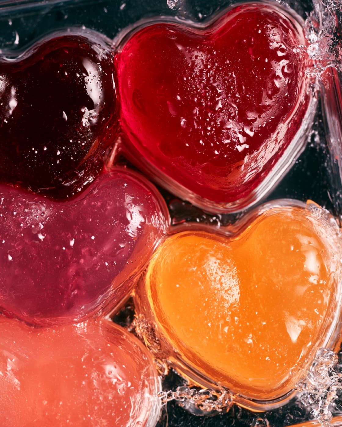 Macro view of fruit gummy hearts under running water